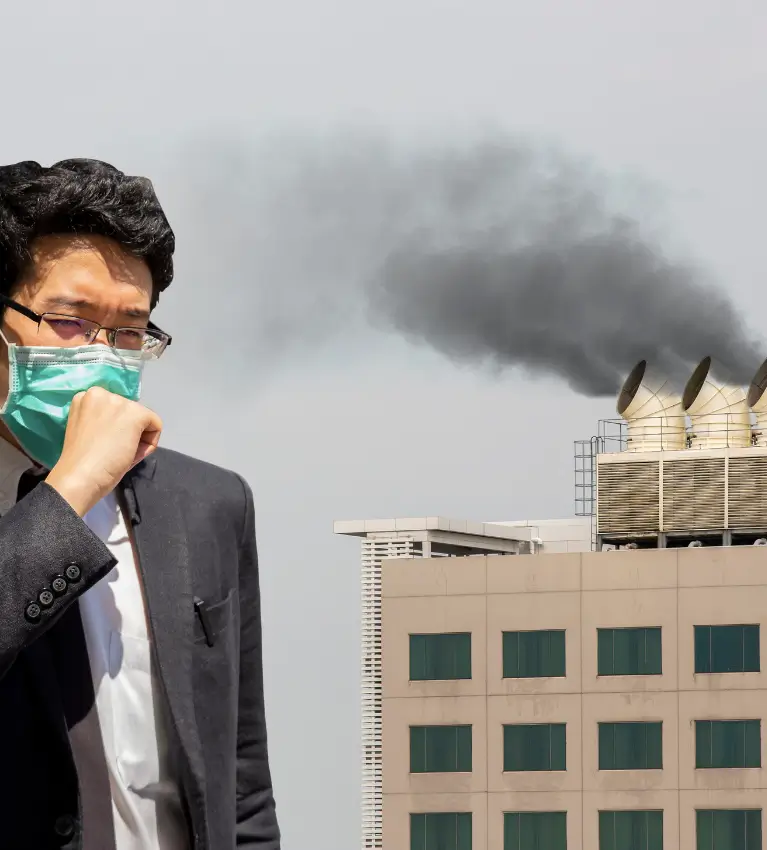 Person wearing protective mask in smoggy outdoor city air pollution impacting breathing and lung function at Dr. L Square Multispecialty Homeopathy Clinic